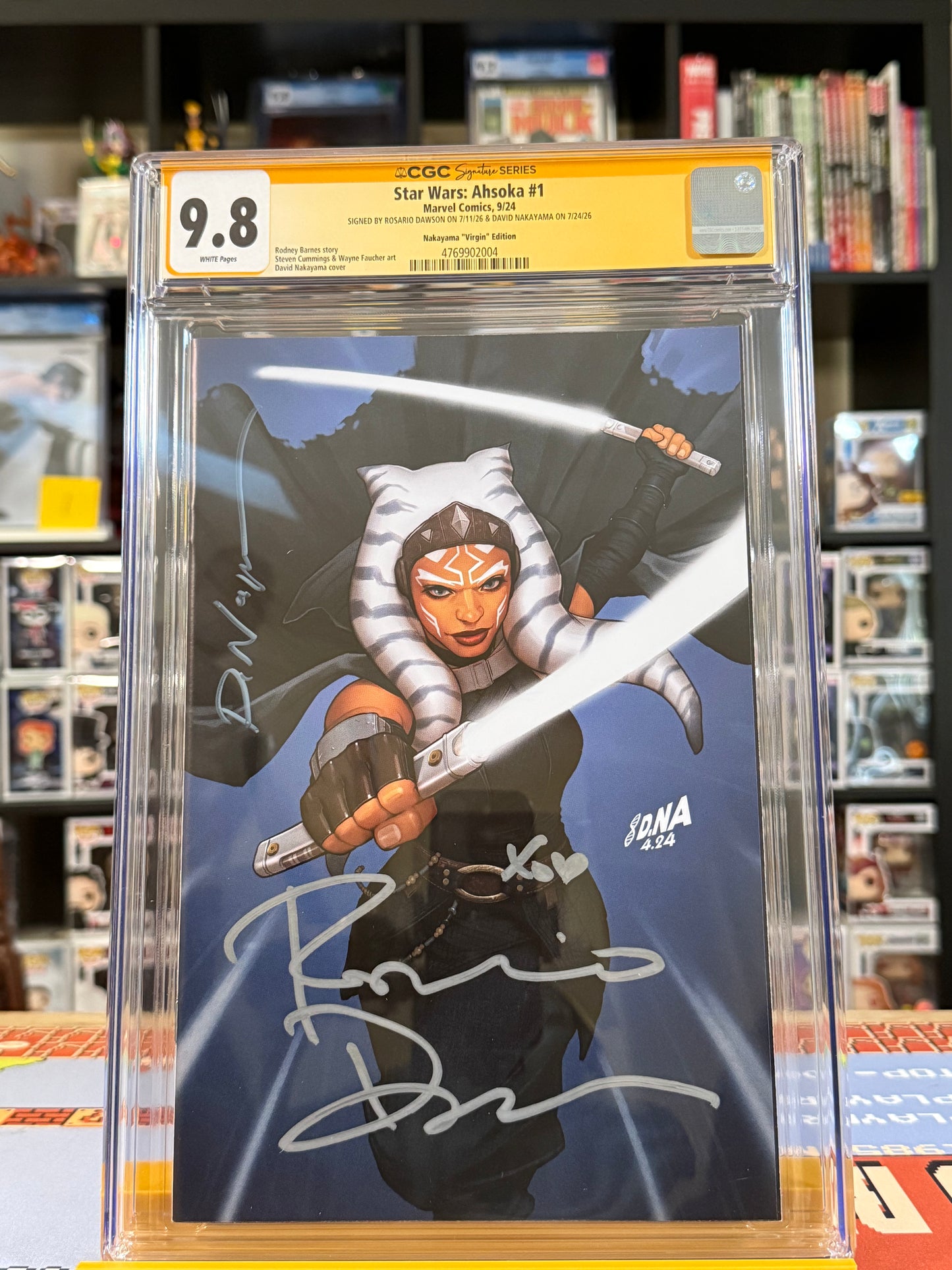Star Wars: Ahsoka #1 David Nakayama Exclusive Virgin Variant CGC Signature Series 9.8 Yellow Label, double signed by Rosario Dawson and David Nakayama, featuring Ahsoka Tano wielding two glowing white lightsabers against a dark blue background, with silver signatures across the virgin cover