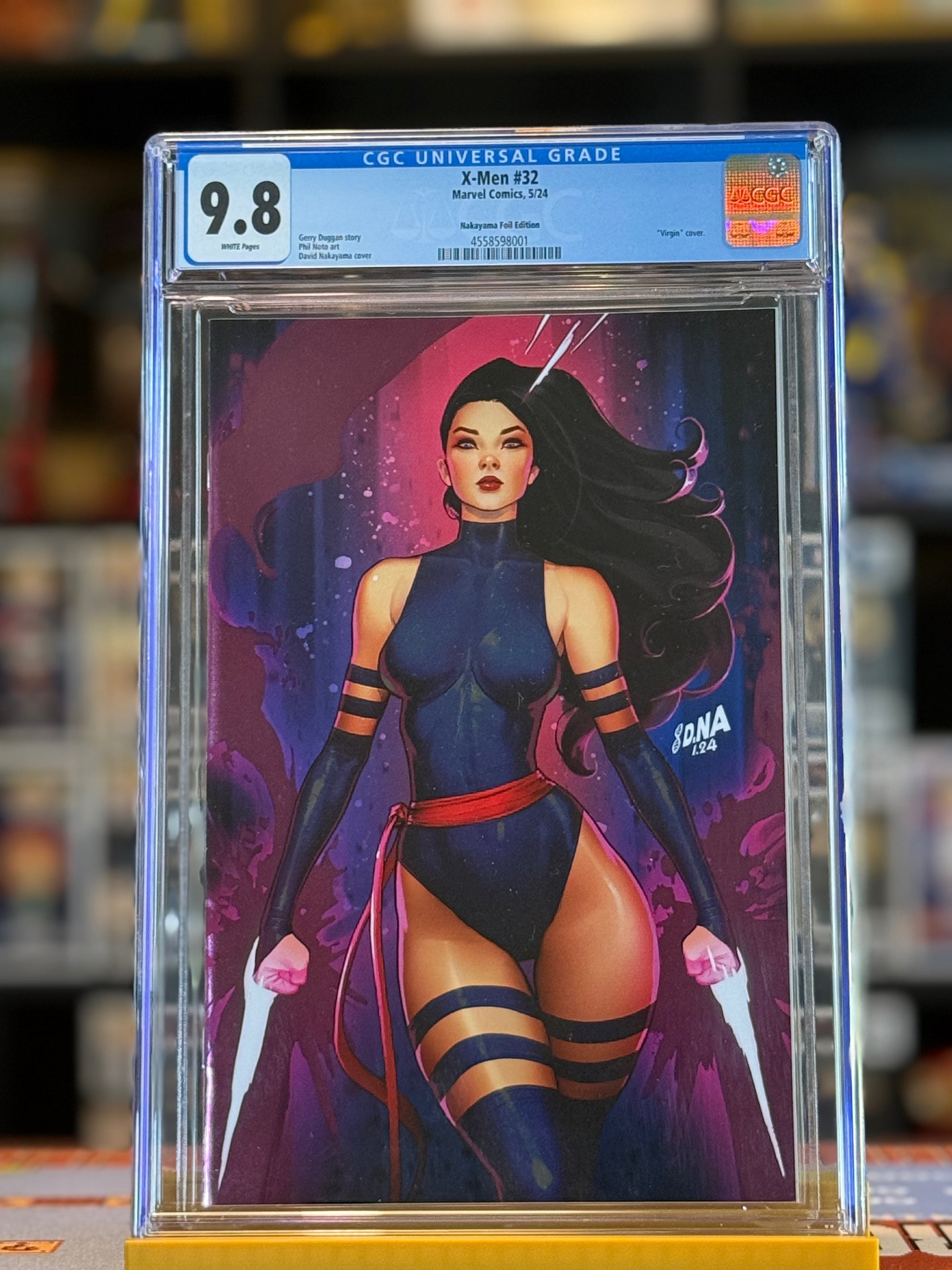Image shows X-Men #32 graded CGC 9.8 in a sealed slab. The cover features Psylocke illustrated by David Nakayama in a dynamic pose, highlighted with metallic spot foil across the artwork. Virgin variant—no trade dress—allowing the full art to stand out.